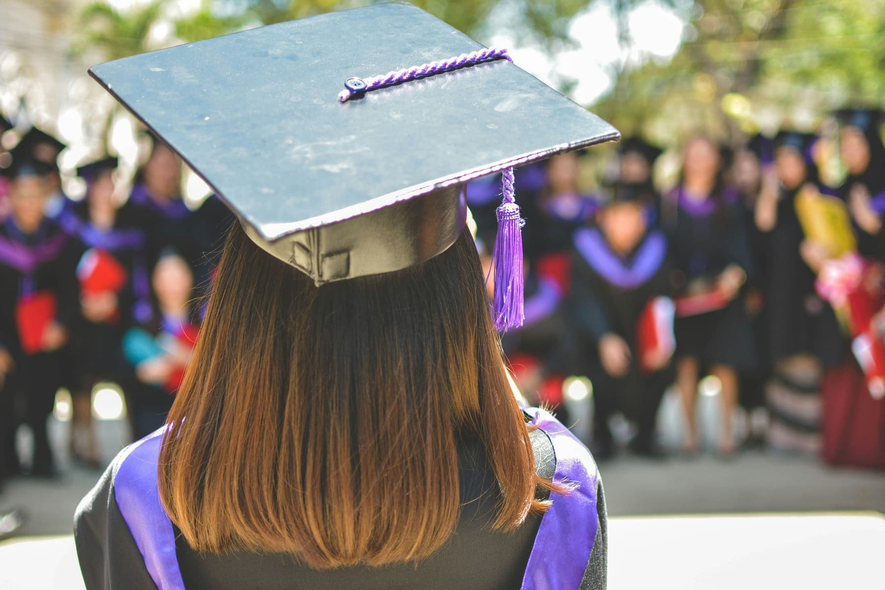 A graduate in cap and gown facing the ceremony